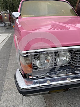 Cropped close up of a retro pink car