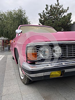 Cropped close up of a retro pink car