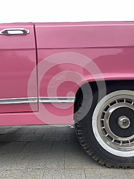 Cropped close up of a retro pink car