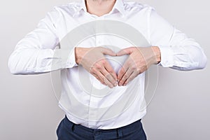 Cropped closeup photo of cheerful handsome nice glad positive guy making heart of two halves on chest isolated grey background