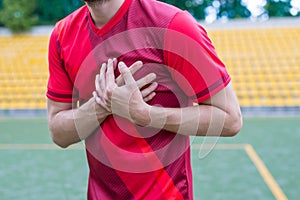 Cropped closeup photo of human`s body touching left side of his body feeling acute pain standing on stadium