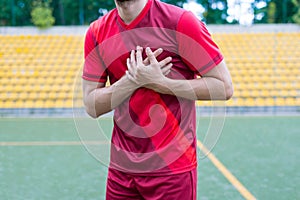 Cropped closeup photo of human`s body touching left side of his body feeling acute pain standing on stadium