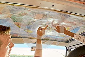 Cropped Couple enjoying travel and wanderlust lifestyle reading map in van