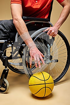 cropped disabled sportsman taking basketball ball from the floor