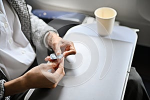 Cropped, A female hands taking an airsick motion sickness pills