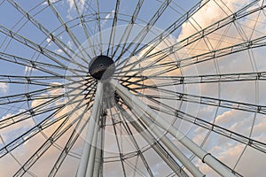 Cropped Ferris wheel at sunset with clouds in the back