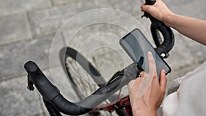 Cropped girl use smartphone on bicycle for routing