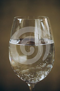 Cropped glass of white wine on a rustic wooden brown background. rest, holiday, party. alcoholic drink closeup. copy space