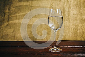 Cropped glass of white wine on a rustic wooden brown background. rest, holiday, party. alcoholic drink closeup. copy space