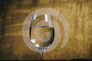 Cropped glass of white wine on a rustic wooden brown background. rest, holiday, party. alcoholic drink closeup. copy space