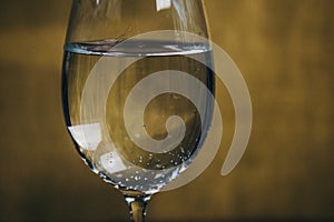 Cropped glass of white wine on a rustic wooden brown background. rest, holiday, party. alcoholic drink closeup. copy space