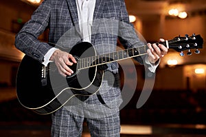 cropped Guitar player in suit performing playing guitar solo sound at concert, on stage