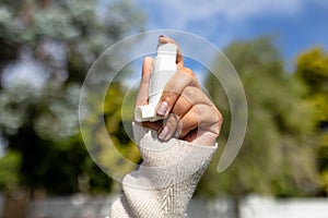 Cropped hand of african american mid adult woman holding asthma inhaler