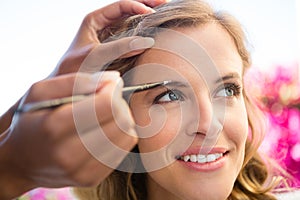 Cropped hand of beautician applying makeup to bride