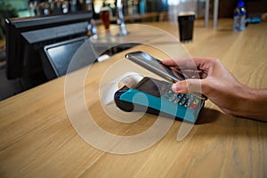 Cropped hand of customer making contactless payment