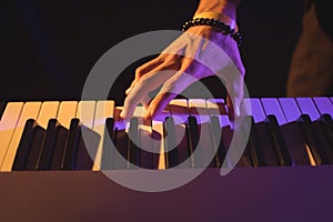 Cropped hand of male musician playing piano