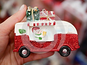 Cropped hand of woman holding christmas toy car. Gift delivery concept.