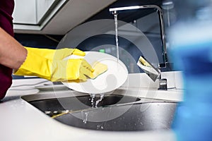 Cropped hand of woman washing plate