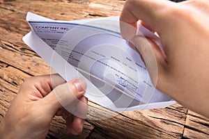 Businessman Opening Envelope With Paycheck photo