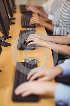 Cropped hands of executives on keyboard in office