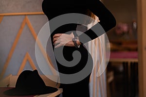 Cropped hoto of lady posing on wooden background in cafe.Fashion style . Girl wearing dark casual dress, .Fashion