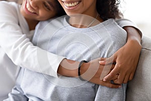 Cropped image of african daughter embracing mother