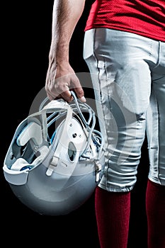 Cropped image of American football player holding helmet