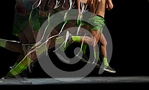 Cropped image of athletic, muscular male legs in motion, running against black background with stroboscope effect.