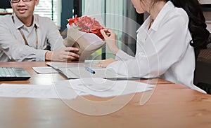 Cropped image of attractive young Asian woman accepting a bouquet of red roses from boyfriend in office on valentine`s day. Love