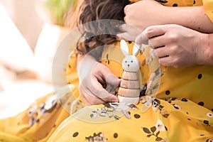 Cropped image of beautiful pregnant woman and her handsome husband. husband hugs pregnant wife in yellow dress