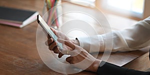 Cropped image of beautiful woman hands holding and using a blank screen smartphone.