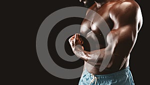 Cropped image of black bodybuilder demonstrating his arm strength