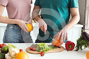 cropped image of boyfriend cutting vegetables for vegetarian salad