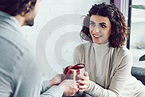 cropped image of boyfriend gifting present to girlfriend