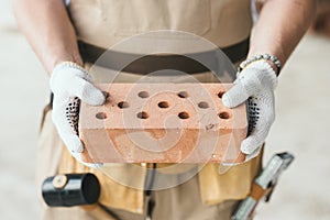 cropped image of builder in protective gloves holding