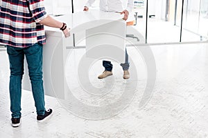 Cropped image of business people relocating table to new office photo