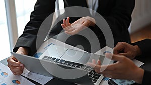 Cropped image of business people talking/meeting/discussing about their business plan by using a computer laptop .