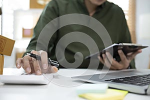 Cropped image of businessman using calculator for calculating financial expenses of small business start up.