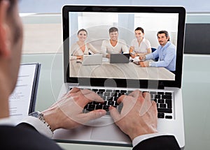 Cropped image of businessman using laptop at desk