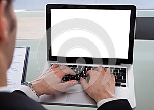 Cropped image of businessman using laptop at desk