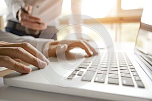 Cropped image of businessmen using laptop for sales performance at a office photo