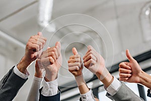 cropped image of businesspeople showing thumbs up