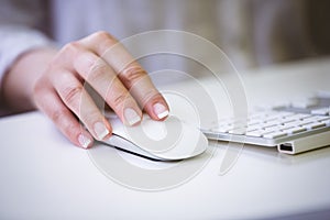 Cropped image of businesswoman using mouse on desk at office