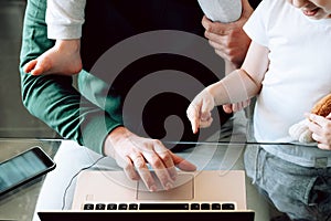 Cropped image of a busy businessman wearing pijamas working from home and watching a child, sitting on his shoulders.