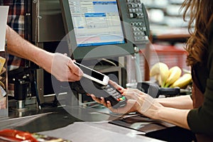 Cropped image of cashier woman create payment with phone app.