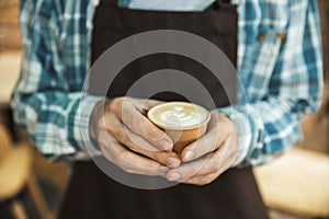 Cropped image of caucasian barista boy making coffee while working in cafe or coffeehouse outdoor