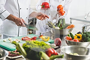 cropped image of chefs preparing vegetables photo