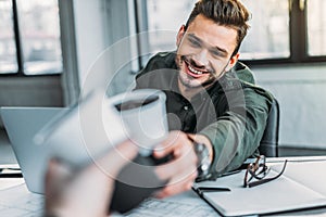 cropped image of colleagues clinking cups of coffee