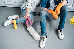 cropped image of couple sitting on floor after cleaning