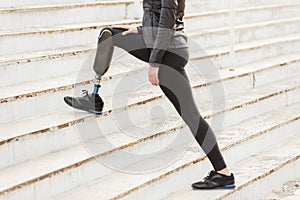 Cropped image of disabled running girl with prosthetic leg in sp